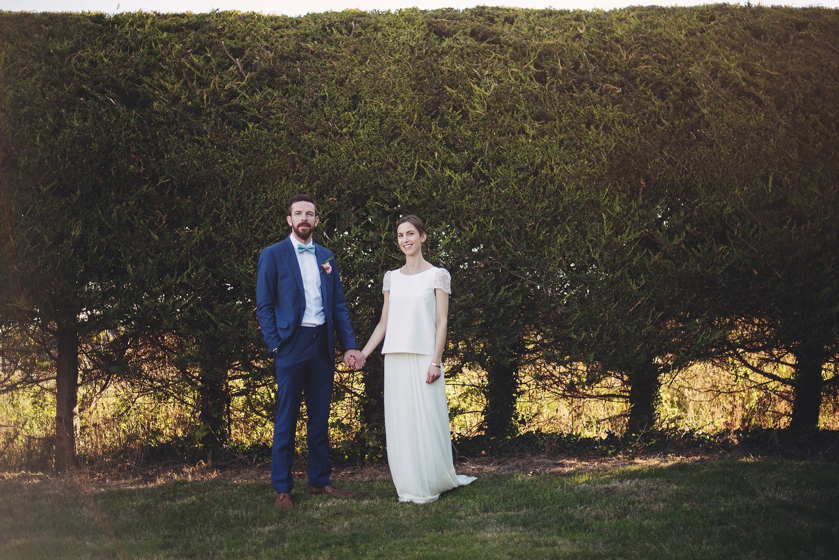 Bride and Groom standing at a nice hedge at their wedding