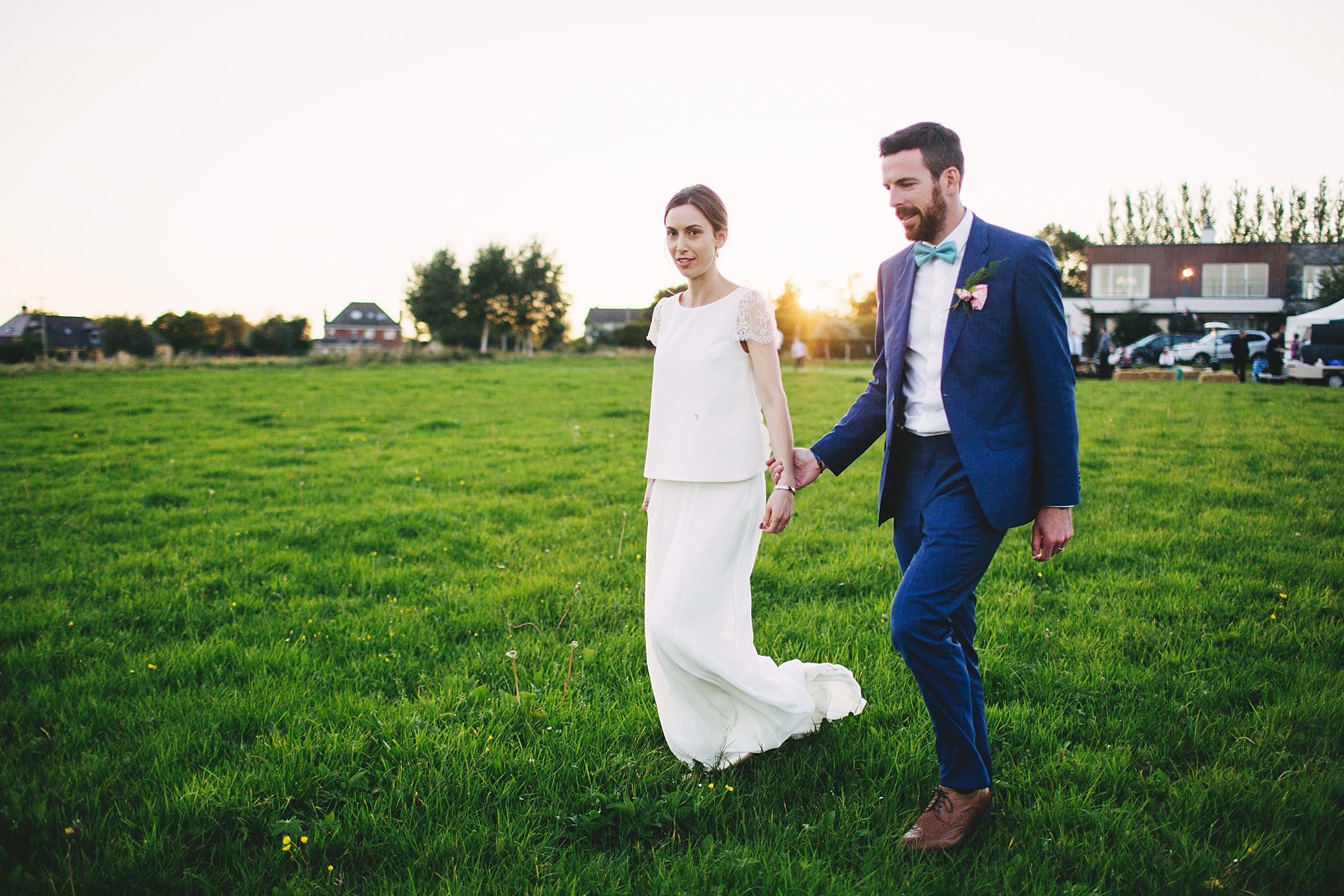 Bride and Groom walking through a field at sunset on a farm in Limerick